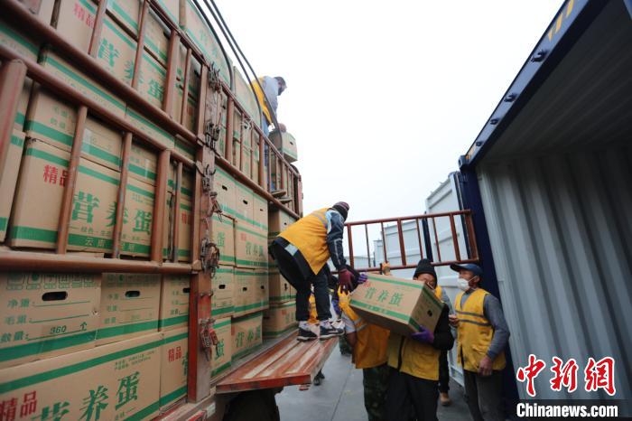 圖為鐵路裝卸作業(yè)人員正在將云南特色農(nóng)產(chǎn)品裝入集裝箱?！詈?攝