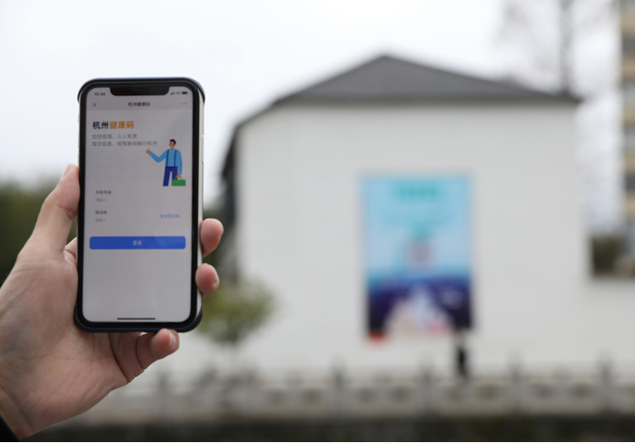 在浙江省杭州市臨安區(qū)天目山鎮(zhèn)，一名居民在“杭州健康碼”海報(bào)上掃碼申領(lǐng)個(gè)人二維碼。新華社發(fā)