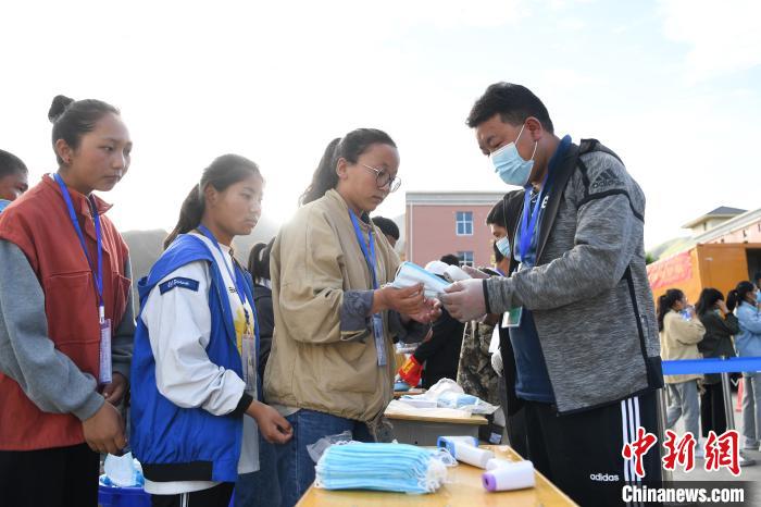 7月7日，考生在拉薩三高考點(diǎn)外領(lǐng)取口罩?！『闻罾?攝