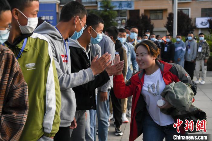 7月7日，拉薩三高考點(diǎn)外，領(lǐng)隊(duì)老師與考生擊掌鼓勁加油?！『闻罾?攝