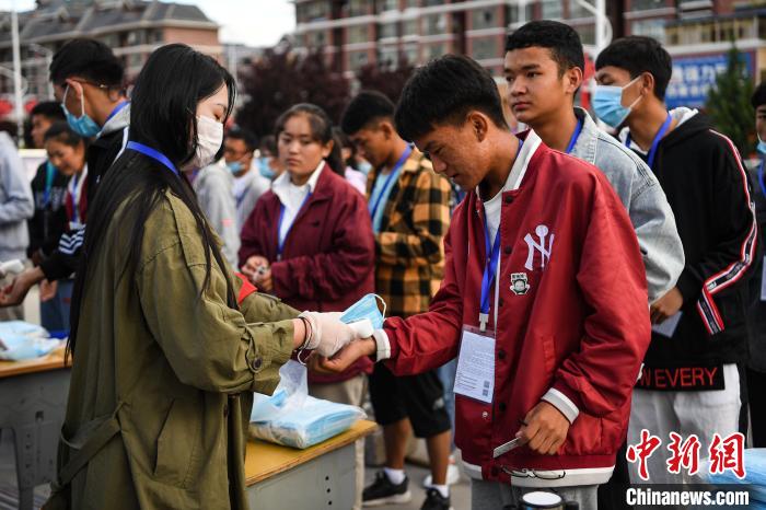 7月7日，考生在拉薩三高考點(diǎn)外測(cè)量體溫?！『闻罾?攝